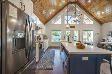 Modern kitchen interior of Bluebird Sky cabin featuring stainless steel appliances, a large island