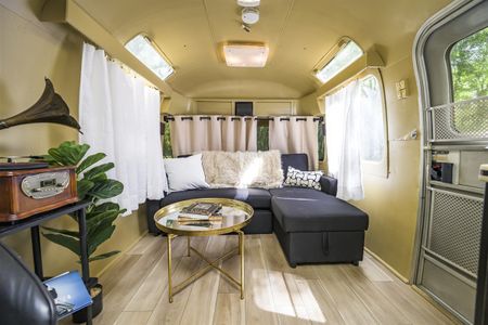 Cozy interior of a vintage Airstream trailer showcasing comfortable seating and stylish decor, evoking