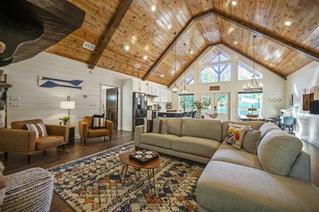 Luxurious cabin interior showcases a spacious living room with a vaulted wood ceiling, comfortable seating