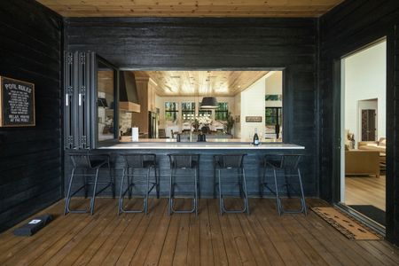 Stylish outdoor bar area with seating, featuring a view of the elegant interior of Bear