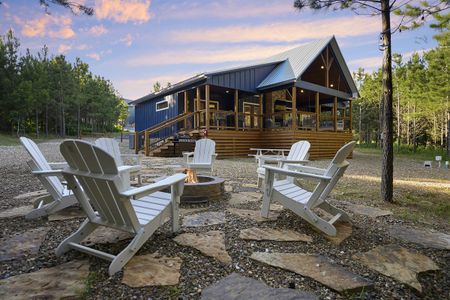 Luxury cabin exterior with Adirondack chairs and a fire pit, perfect for campfire stories