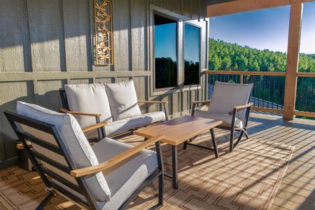 Outdoor sofa and chairs around a coffee table on a wooden deck
