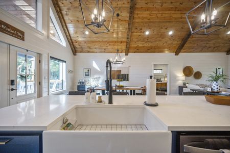 Luxury cabin interior showcasing a spacious kitchen with a white farmhouse sink, modern black fixtures