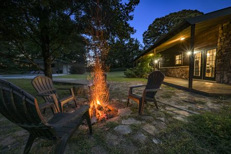 Cozy cabin with a crackling fire pit and comfortable Adirondack chairs, offering comfort and convenience
