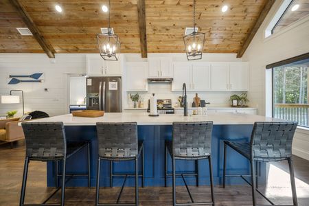 Modern kitchen interior of Bluebird Sky cabin featuring a large island with bar stools, stainless