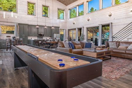 Pool table in a cabin game room beside large windows