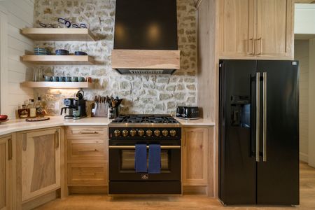 Luxurious kitchen at Bear Lake Lodge, featuring a spacious layout with a black refrigerator, stone