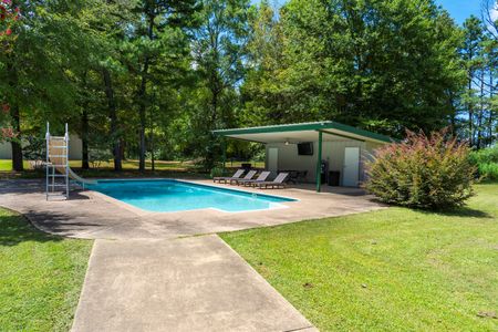 Backyard pool area featuring a clear blue swimming pool, lounge chairs, and a shaded pavilion