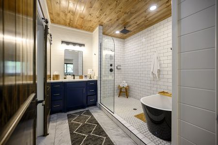Luxurious bathroom interior in Bluebird Sky cabin featuring a walk-in shower with white tile