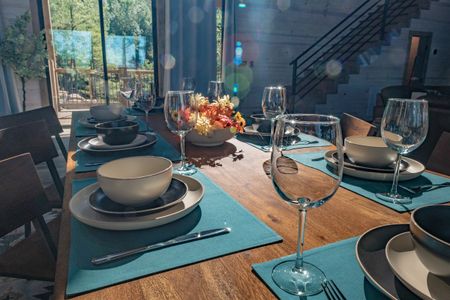 Dining table set with bowls, plates and turquoise placemats
