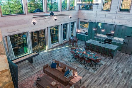 Cabin deck with outdoor seating and a table beside large windows