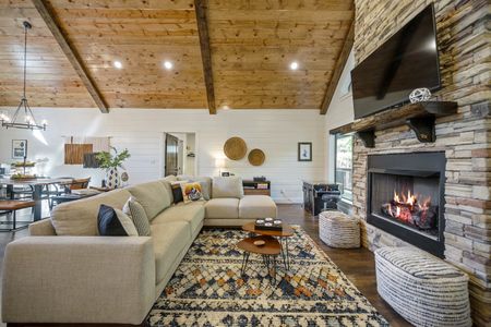 Spacious living room in Bluebird Sky cabin featuring a stone fireplace, comfortable sectional sofa