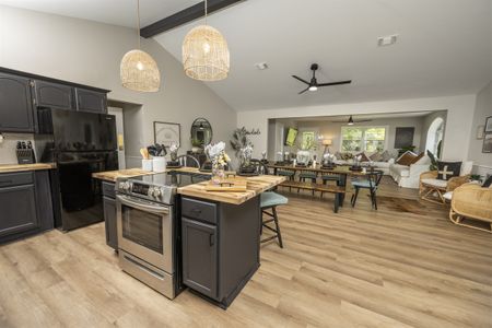 Modern kitchen interior featuring dark cabinetry, stainless steel appliances, and an open layout connecting
