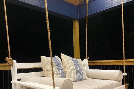 Twin-size porch swing bed with plush cushions and pillows offering a tranquil outdoor relaxation space