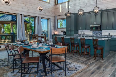 Wooden dining table and chairs beside a green kitchen island