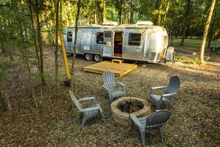 Cozy cabin and modern home rental featuring a vintage silver Airstream trailer nestled among trees