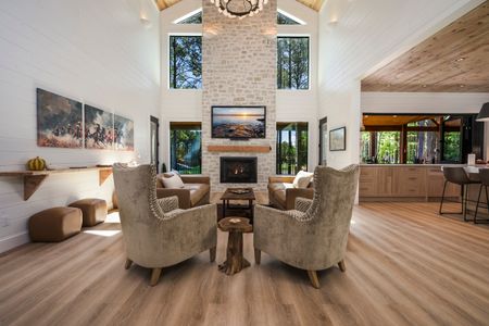 Luxurious living area at Bear Lake Lodge featuring cozy armchairs, a stone fireplace, and large