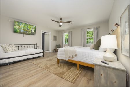 Cozy bedroom interior featuring a large bed, twin daybed, and modern furnishings, showcasing comfort
