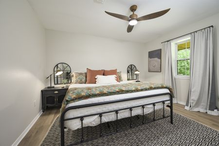 Cozy cabin bedroom interior featuring a black metal bed with patterned bedding, bedside tables