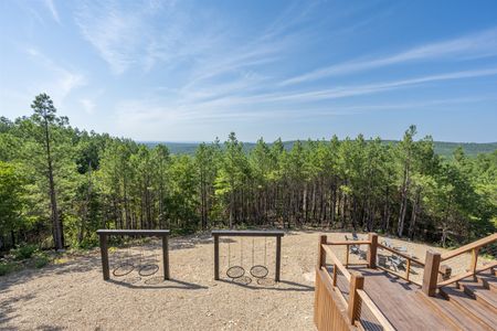 Wooden swing set and deck overlooking a lush forest view from A View