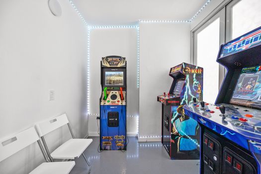 Ingrese a un emocionante reino de nostalgia y entretenimiento en esta animada sala de juegos, que exhibe juegos de arcade tradicionales junto con elementos de diseño contemporáneo.