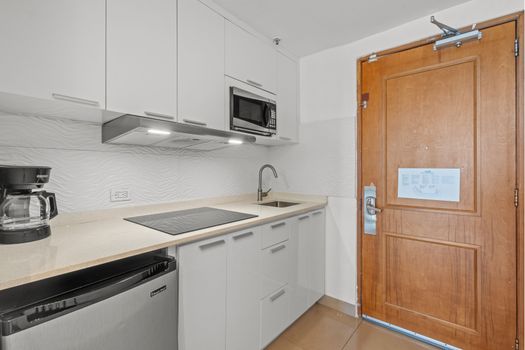 Enjoy the convenience of a compact yet complete kitchen, thoughtfully designed with everything you need for a comfortable stay, including a refrigerator, stovetop, and ample counter space.