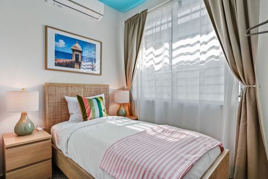 A cozy retreat featuring a stylish rattan headboard and inviting bedding.