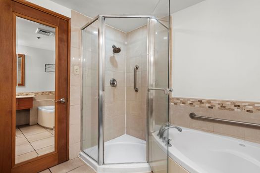 Refresh yourself in the spacious walk-in shower with clear glass doors, offering a clean and modern bathing experience