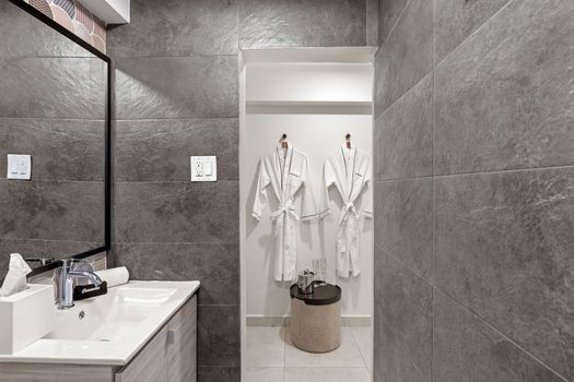 This minimalist bathroom offers a spa-like ambiance with its neutral color palette, clean lines, and luxurious amenities for a relaxing retreat.