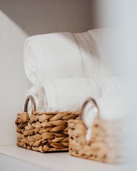 Discover a hint of cozy home luxury with neatly organized baskets of crisp white towels.