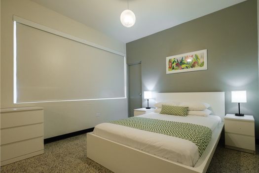 Experience a blend of contemporary style and cozy comfort in this inviting bedroom, featuring a comfortable bed and soothing ambiance for a relaxing stay