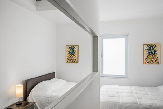 Experimente un sueño reparador en este dormitorio moderno que cuenta con una cama espaciosa, una decoración artística en las paredes y elegantes lámparas de noche que emiten un brillo cálido.