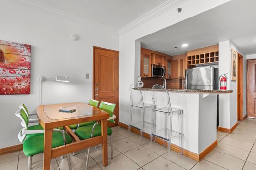 Chic kitchen and bar area featuring clear bar stools, perfect for casual dining and enjoying a drink.