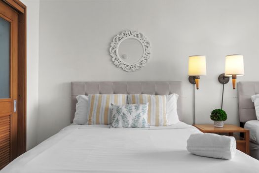Sink into this plush, neatly made bed, featuring crisp white linens and inviting decorative pillows
