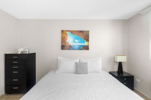 Enjoy the simplicity of our stylish bedroom, featuring a large comfortable bed and ample natural light.