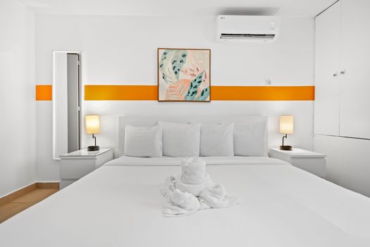 Above the bed hangs an abstract art piece, complementing the room’s modern aesthetic.