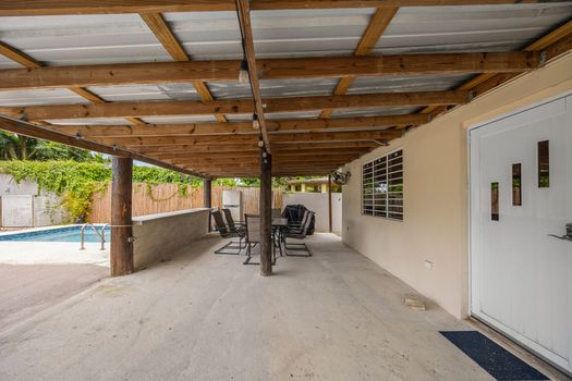 Spacious covered patio by the sparkling pool.