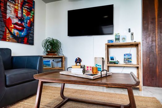 Relax in style in our inviting living area, complete with a large wall-mounted TV for your entertainment and a comfortable sofa.