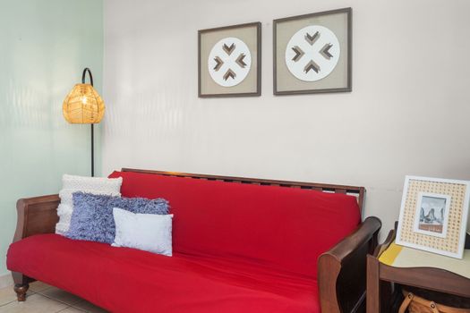Snuggle up in this cozy corner with a vibrant red sofa, perfect for relaxing evenings or lazy afternoons.