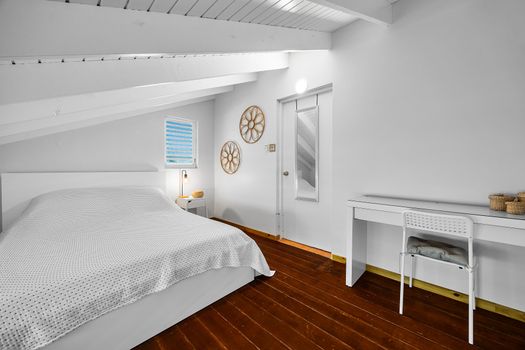 Cozy under the eaves. Sleep soundly in this peaceful space with soft lighting and beachy touches.