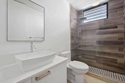 Sleek bathroom featuring a stylish vessel sink & spacious shower.