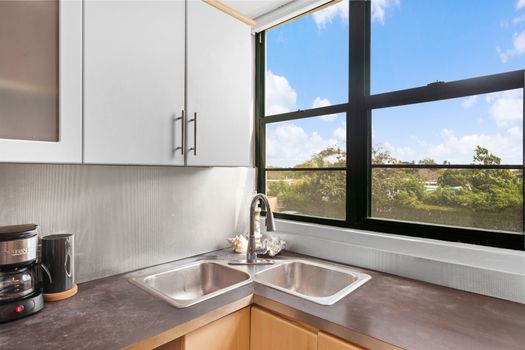 Delight in our modern kitchen, bathed in natural light from the expansive window, complete with top-notch appliances and a charming dining area.