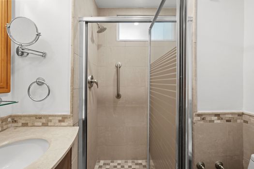 Bright and modern bathroom featuring a spacious walk-in shower with clear glass doors for an open feel.