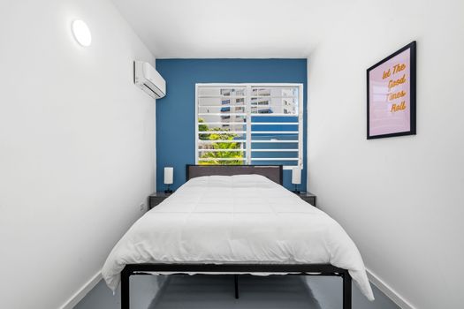Relax in a stylish, modern room with a striking blue accent wall, cozy white rocking chairs with orange pillows, and a flat-screen TV for your entertainment.