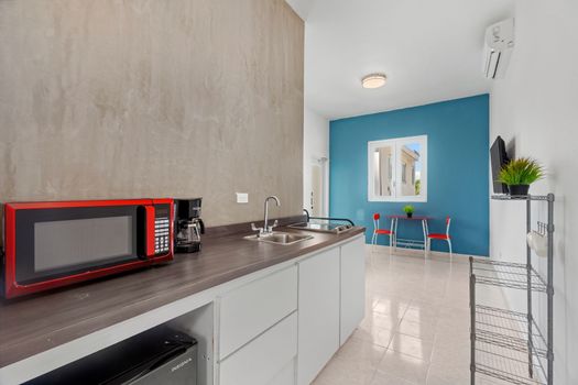 Enjoy the convenience of a fully equipped kitchenette, featuring a sleek countertop, microwave, and refrigerator – perfect for preparing snacks or light meals during your stay.