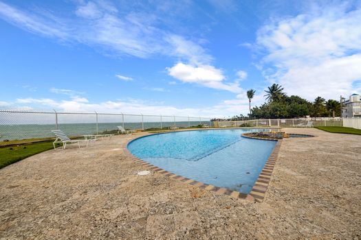 Nuestra área al aire libre se completa con una prístina piscina y jacuzzi, con un telón de fondo de palmeras y cielos despejados.