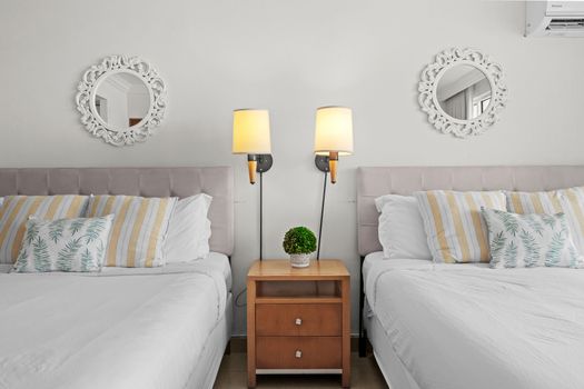 Thoughtfully designed bedroom with dual beds, each featuring cozy bedding and individual reading lamps