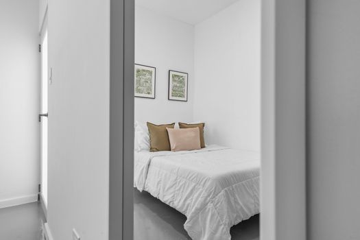 Nuestra habitación cuenta con una acogedora cama con sábanas blancas impecables contra una pared decorativa en azul intenso, lo que ofrece un refugio tranquilo para los exploradores de la ciudad.