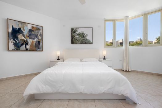 Serene master bedroom featuring a king-size bed and artistic decor.