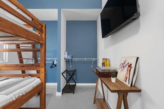 Experience comfort in our well-lit room featuring a sturdy wooden bunk bed. Ideal for friends or family traveling together.